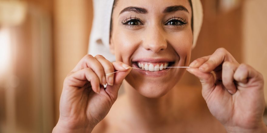 beautiful-woman-using-dental-floss-cleaning-her-teeth-bathroom-min