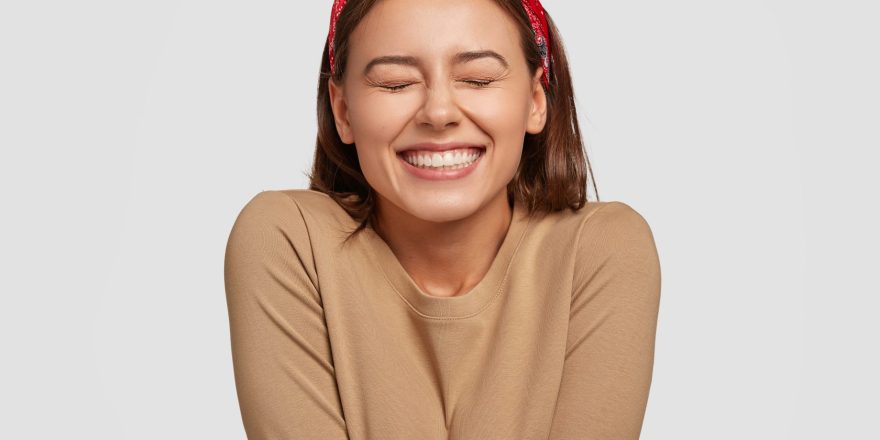 portrait-happy-european-woman-has-broad-smile-closes-eyes-feels-excitement-being-high-spirit-min