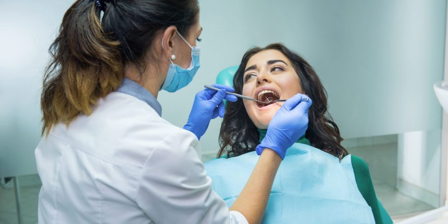 woman-dentist-stomatologist-mask-working-oral-health-assessment-min